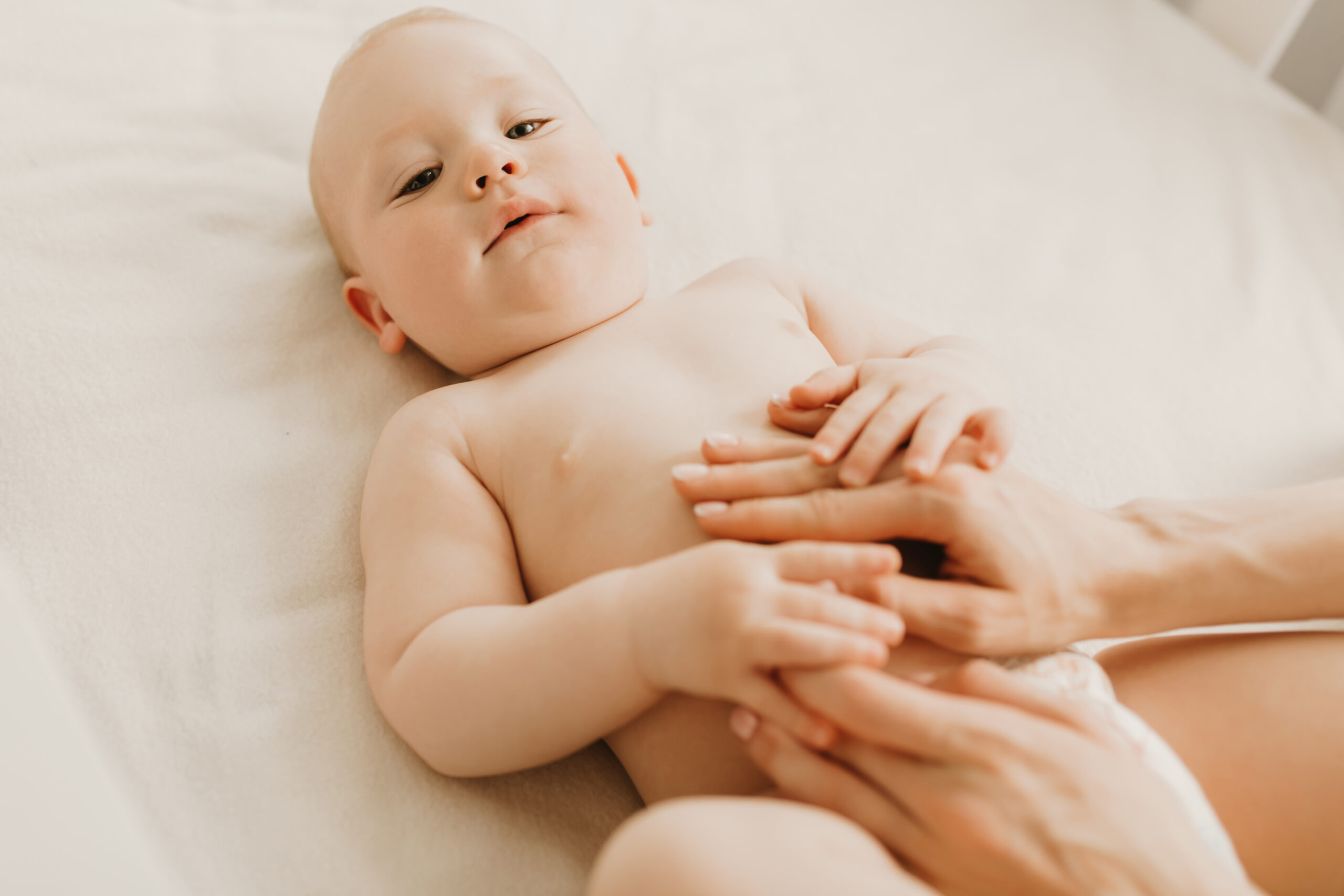 Baby massage, Mom massages the baby's belly during colic